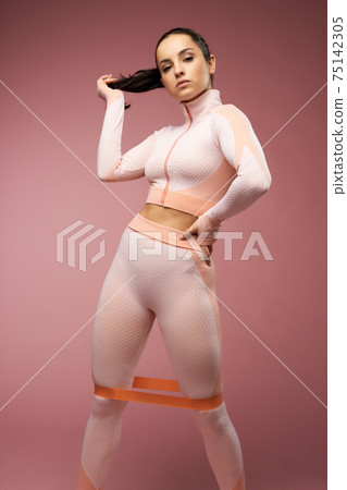 Beautiful young woman in sportswear using fitness band Beautiful young woman in sportswear using fitness band 75142305