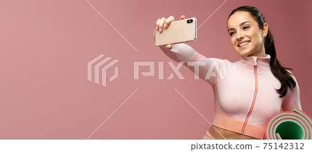 Website header of Cheerful young woman with yoga mat making selfie 75142312