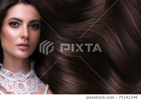 Beautiful brown-haired girl with a perfectly curls hair, and classic make-up. Beauty face and hair. 75142346
