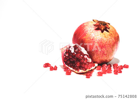 One ripe red pomegranate and a piece of pomegranate with grains One ripe red pomegranate and a piece of pomegranate with grains 75142808