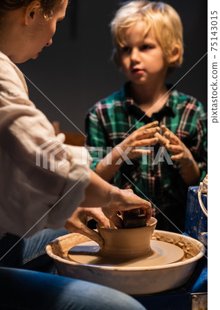 a pottery lesson at an art school is taught by a young girl a potter for a cute child. a pottery lesson at an art school is taught by a young girl a potter for a cute child. 75143015