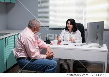 A geriatric doctor having a senior patient in her office 75143452