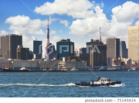 [Shibaura, Tokyo] A tugboat operating at Tokyo Port, Hinode Pier Warehouse and Tokyo Tower in the background. 75145014