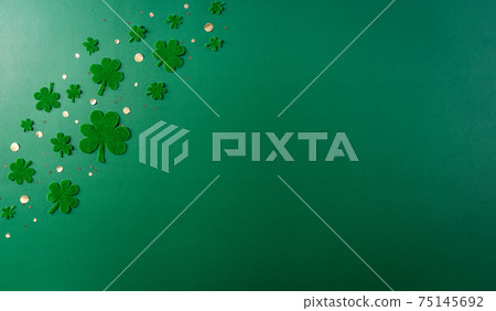 Happy St. Patricks Day decoration concept. Flat lay, top view of clover leaves on green background with space for text. Happy St. Patricks Day decoration concept. Flat lay, top view of clover leaves on green background with space for text. 75145692
