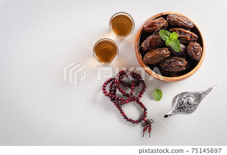 Table top view image of decoration Ramadan Kareem, dates fruit, aladdin lamp and rosary beads on gray background. Flat lay with copy space. Table top view image of decoration Ramadan Kareem, dates fruit, aladdin lamp and rosary beads on gray background. Flat lay with copy space. 75145697