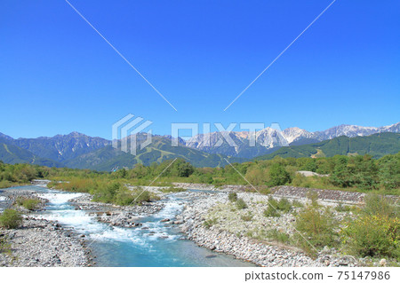 The northern Alps and clear stream at the foot of Mt. Hakuba in early autumn The northern Alps and clear stream at the foot of Mt. Hakuba in early autumn 75147986
