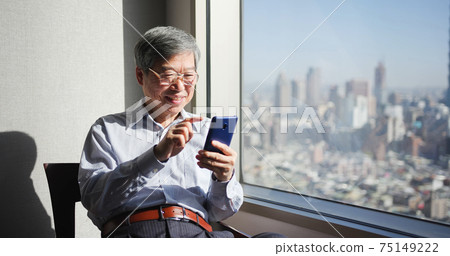 man use smartphone near window man use smartphone near window 75149222