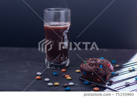 Chocolate muffin and cocoa in a glass. Snack with muffins and cocoa. Chocolate muffin and cocoa in a glass. Snack with muffins and cocoa. 75150960
