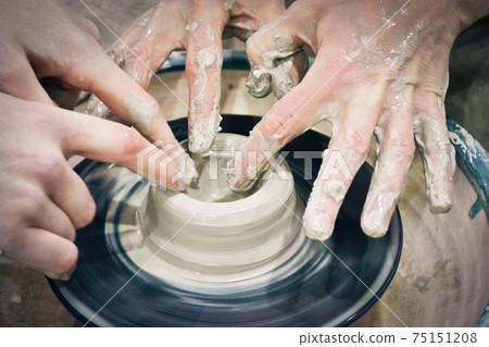 The potter molds a jug on the circle 75151208