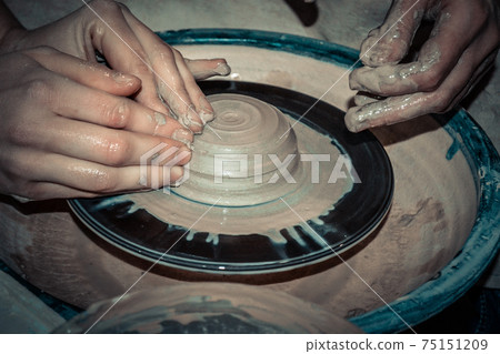 The potter molds a jug on the circle 75151209