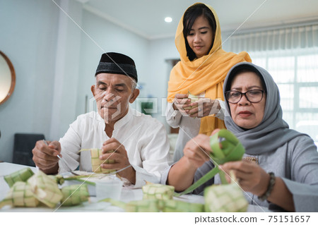 senior muslim couple and daughter making ketupat for eid fitr mubarak senior muslim couple and daughter making ketupat for eid fitr mubarak 75151657