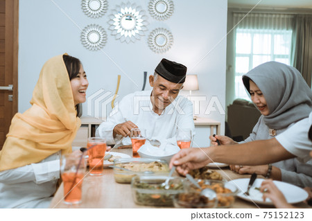 beautiful asian family enjoying their iftar dinner at home 75152123