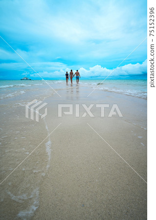 Family walking on the white sand beach 75152396