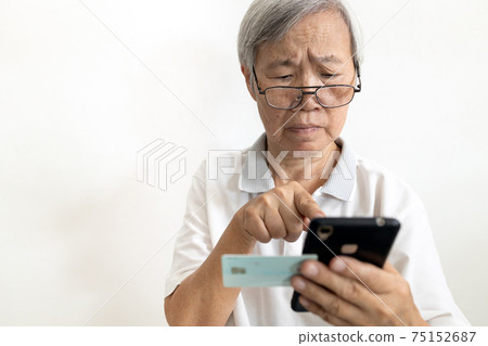 Confused senior woman hold cell phone ID card,unable to enter registration website,complex access is difficult for old people,elderly fill out information via mobile application to register online Confused senior woman hold cell phone ID card,unable to enter registration website,complex access is difficult for old people,elderly fill out information via mobile application to register online 75152687