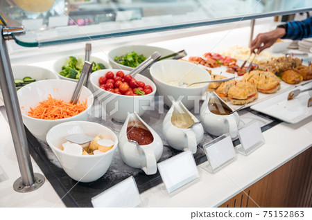 Salad bar with variety sauce, topping vegetables and bread on the buffet table 75152863