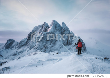 Mountaineer woman standing on top of Segla peak with majestic mountain in snowy on winter at Senja 75152890