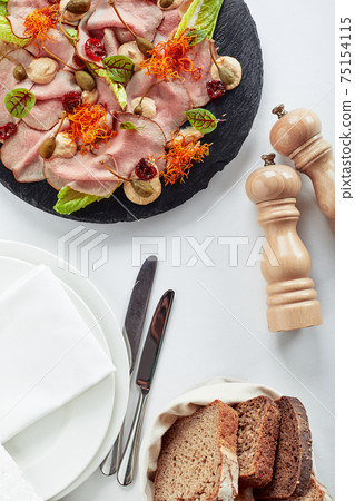 Sliced Beef or Pork with Marinated Vegetables and Sauce. Beautifully decorated catering banquet menu. Food snacks and appetizers for buffet on white background 75154115