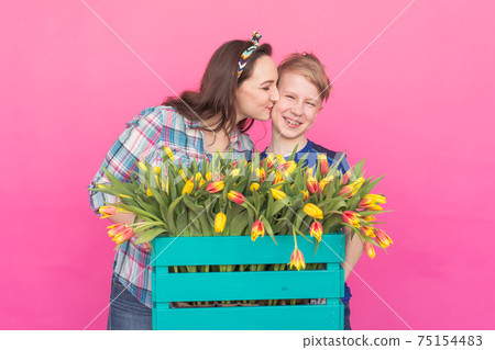 Family portrait sister and teenager brother with tulips on pink background Family portrait sister and teenager brother with tulips on pink background 75154483