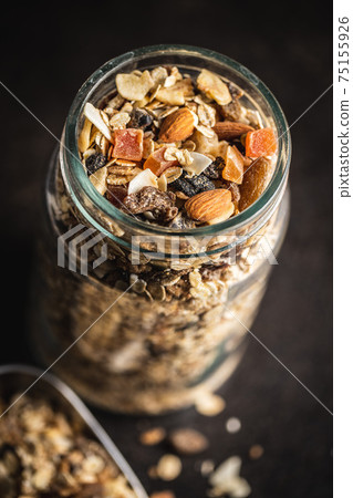 Beakfast cereals in jar. Healthy muesli with oat flakes, nuts and raisins 75155926