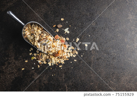 Beakfast cereals in scoop. Healthy muesli with oat flakes, nuts and raisins Beakfast cereals in scoop. Healthy muesli with oat flakes, nuts and raisins 75155929