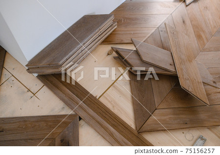 Man laying parquet flooring - closeup on male hands. worker joining parquet floor 75156257