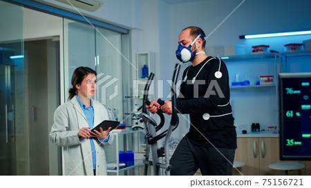 Slow motion shot of sport scientist looking at tablet with EKG scan 75156721