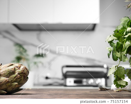 Cooking artichokes at modern white kitchen 75157154