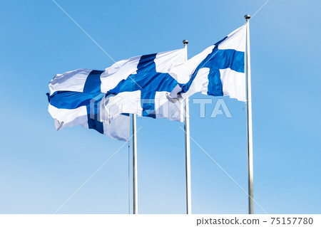 Three finnish national flags on the wind against the blue sky Three finnish national flags on the wind against the blue sky 75157780