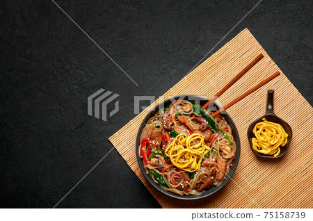 Japchae in black bowl on dark slate table top. Korean cuisine food glass chapchae noodles dish  75158739