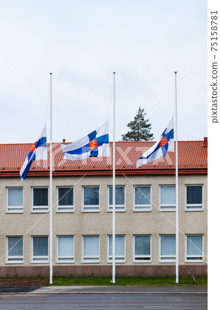 Three finnish flags lowered to half mast on the occasion of mourning at cloudy autumn day Three finnish flags lowered to half mast on the occasion of mourning at cloudy autumn day 75158781