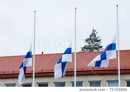Three finnish flags lowered to half mast on the occasion of mourning at cloudy autumn day Three finnish flags lowered to half mast on the occasion of mourning at cloudy autumn day 75158800