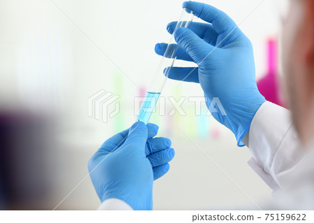 A male chemist holds test tube of glass in his hand overflows 75159622