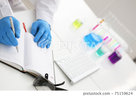 Employee of the chemical laboratory teacher chemist holds a silvery pen Employee of the chemical laboratory teacher chemist holds a silvery pen 75159624