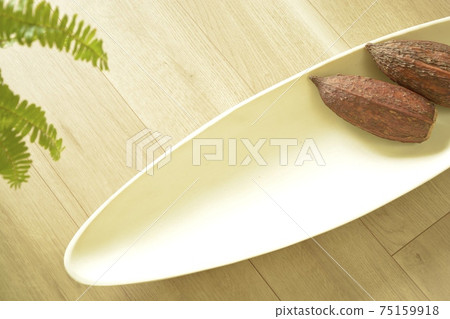 Copy space on white plate. With cocoa pod (white background, soft focus) Copy space on white plate. With cocoa pod (white background, soft focus) 75159918
