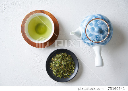 綠茶和茶葉倒入茶杯 75160341