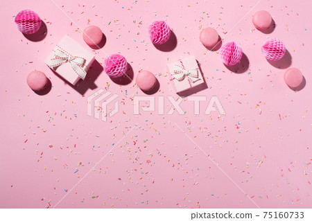 Flat lay composition with sweet cakes macaroons, sprinkles, pink gift boxes and paper decorations on pink background. 75160733