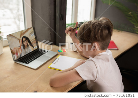Little boy studying by group video call, use video conference with teacher, listening to online course 75161051