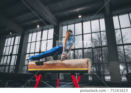 Little male gymnast training in gym, flexible and active. Caucasian fit little boy, athlete in sportswear practicing in exercises for strength, balance. 75161623