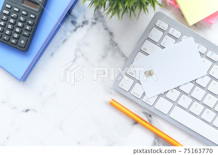 high angle view of credit cards on keyboard on white background high angle view of credit cards on keyboard on white background 75163770