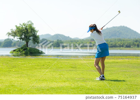 Golfer sport course golf ball fairway. People lifestyle woman playing game golf and hitting go on green grass Golfer sport course golf ball fairway. People lifestyle woman playing game golf and hitting go on green grass 75164937