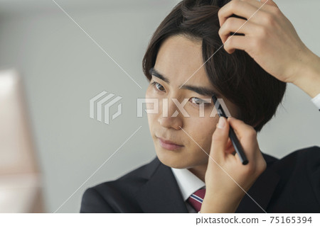 Image of young men in suits drawing eyebrows, men's makeup Image of young men in suits drawing eyebrows, men's makeup 75165394