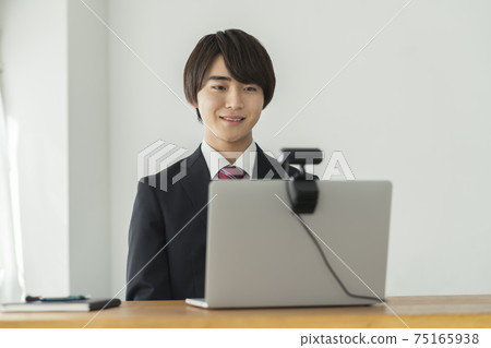 與網絡攝像頭交談的年輕男性視頻聊天在線採訪的圖像 75165938