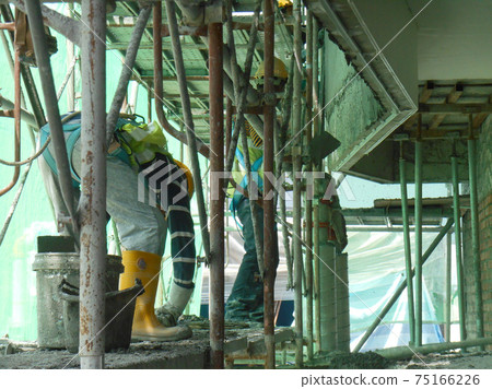 SERDANG, MALAYSIA -JULY 25, 2017: Construction workers plastering building wall and beam using cement plaster with mix of cement, sand & lime at the construction site. 75166226