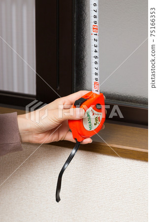Female hand to measure curtain dimensions Female hand to measure curtain dimensions 75166353