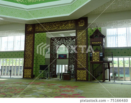 CYBERJAYA, MALAYSIA -JULY 04, 2017: Interior of Masjid Raja Haji Fisabillillah. Front decorative panel made from solid timber and carved Koran words. CYBERJAYA, MALAYSIA -JULY 04, 2017: Interior of Masjid Raja Haji Fisabillillah. Front decorative panel made from solid timber and carved Koran words. 75166480