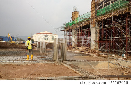 KUALA LUMPUR, MALAYSIA -JULY 30, 2020: Construction workers mixing and spraying the anti-termite chemical treatment to the soil at the construction site. KUALA LUMPUR, MALAYSIA -JULY 30, 2020: Construction workers mixing and spraying the anti-termite chemical treatment to the soil at the construction site. 75167426