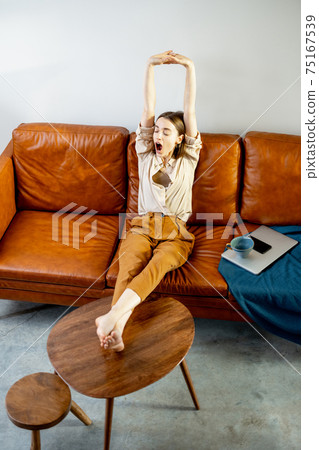 Woman relaxing on the sofa at home Woman relaxing on the sofa at home 75167539