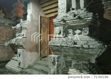 JOGJAKARTA, INDONESIA -JUNE 12, 2014: Entrance arch at old Masjid Besar Mataram Kotagede, Jogjakarta Indonesia. The arch was made from brick and hand made carving stone in traditional Balinese Style 75168196