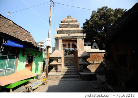 JOGJAKARTA, INDONESIA -JUNE 12, 2014: Entrance arch at old Masjid Besar Mataram Kotagede, Jogjakarta Indonesia. The arch was made from brick and hand made carving stone in traditional Balinese Style JOGJAKARTA, INDONESIA -JUNE 12, 2014: Entrance arch at old Masjid Besar Mataram Kotagede, Jogjakarta Indonesia. The arch was made from brick and hand made carving stone in traditional Balinese Style 75168218