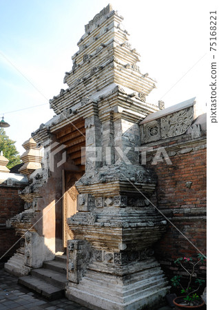 JOGJAKARTA, INDONESIA -JUNE 12, 2014: Entrance arch at old Masjid Besar Mataram Kotagede, Jogjakarta Indonesia. The arch was made from brick and hand made carving stone in traditional Balinese Style 75168221